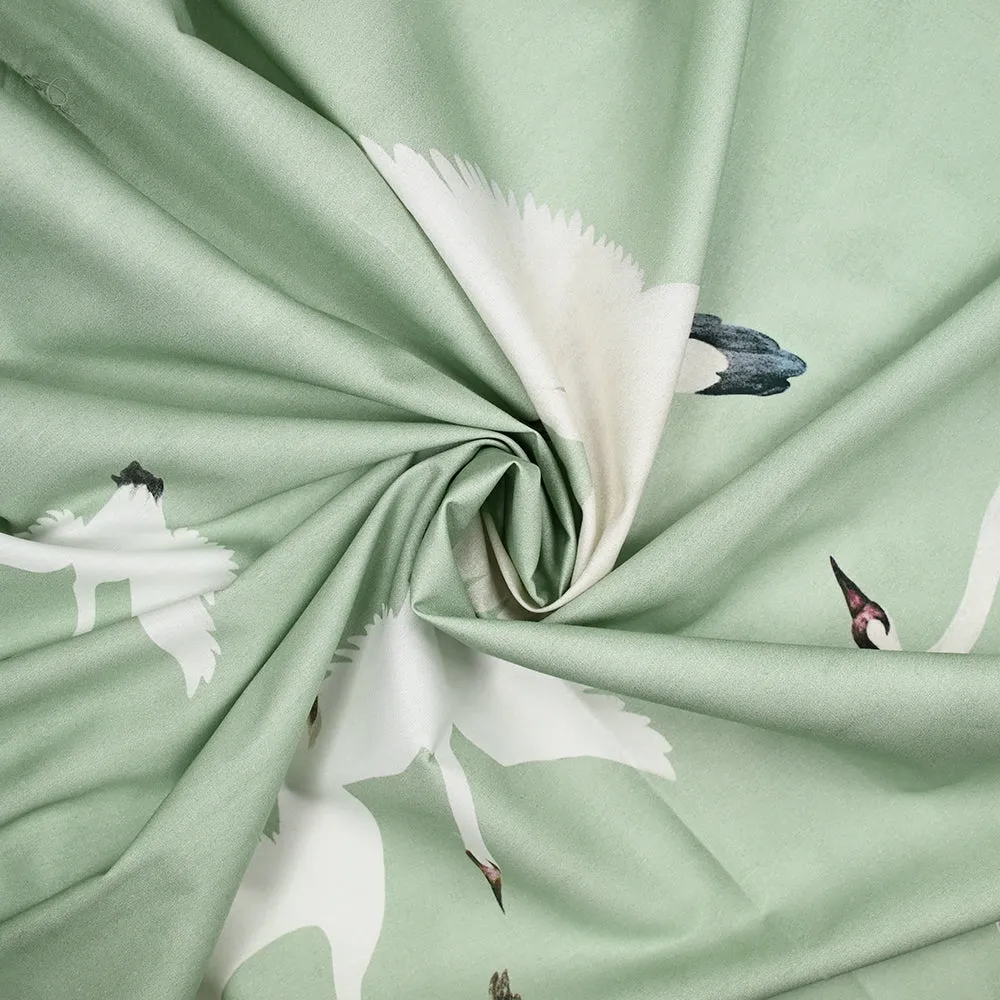 Coton imprimé envolée cygnes écru fond vert pastel